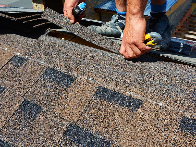 close up of a roofing contractor installing shingle roof broadell nc
